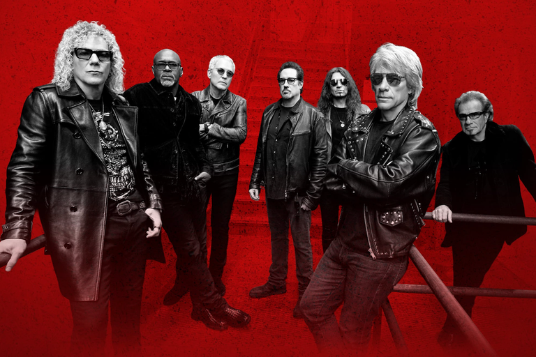Rock band Bon Jovi posing together in leather jackets against a striking red background.